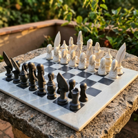 Outdoor chess set with black and white pieces on a stone surface