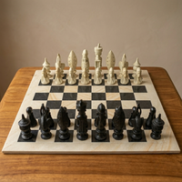 Chessboard with black and white chess pieces on a wooden surface.