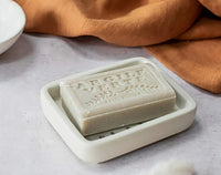 Bar of soap in a white dish with 'Argile Verte' branding on a light background.