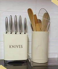 Knife block and utensil holder on a kitchen counter with white tiled wall background