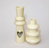 Two cream-colored ceramic vases on a light gray background