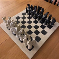 Chessboard with black and white chess pieces on a wooden surface