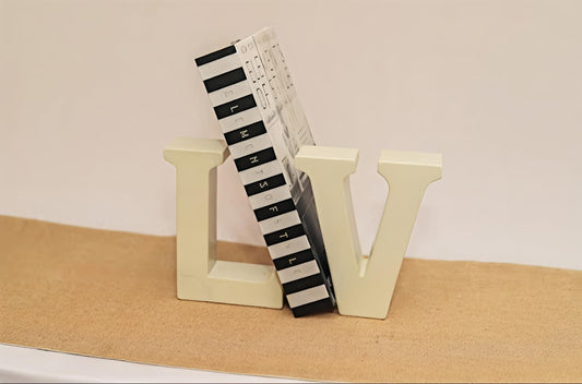 Black and white striped object on beige 'L' and 'V' blocks against a beige background