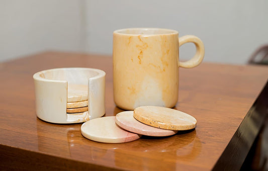 Marble-patterned mug with coasters on a wooden surface