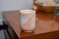 Ceramic cup with marbled design on a wooden surface