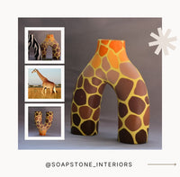 Decorative item with giraffe pattern on a gray background, featuring @soapstone_interiors.